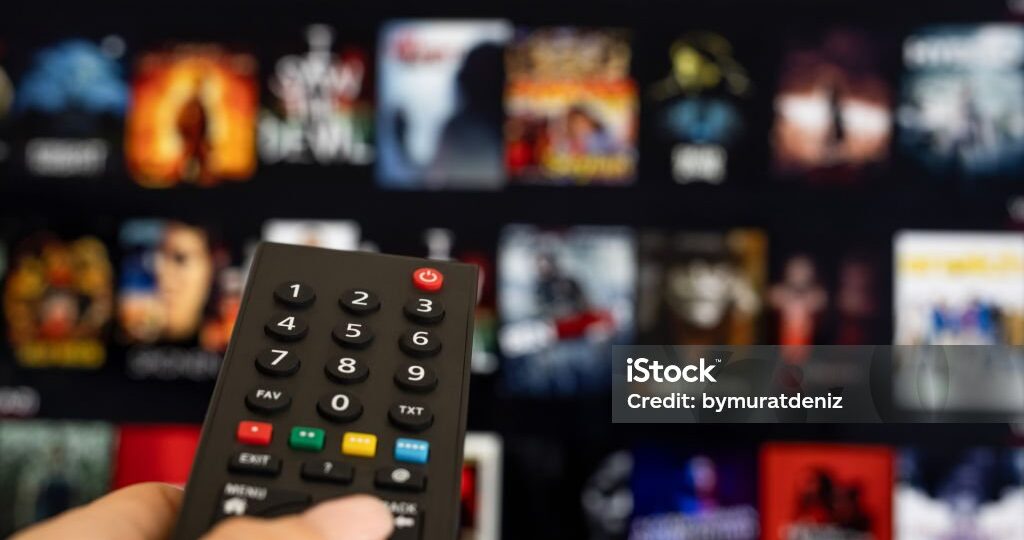 Woman hand holding tv remote.